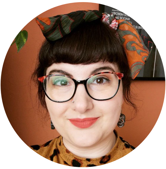 A photograph of the illustrator Lottie Thomson, a white woman with glasses and dark hair with a fringe